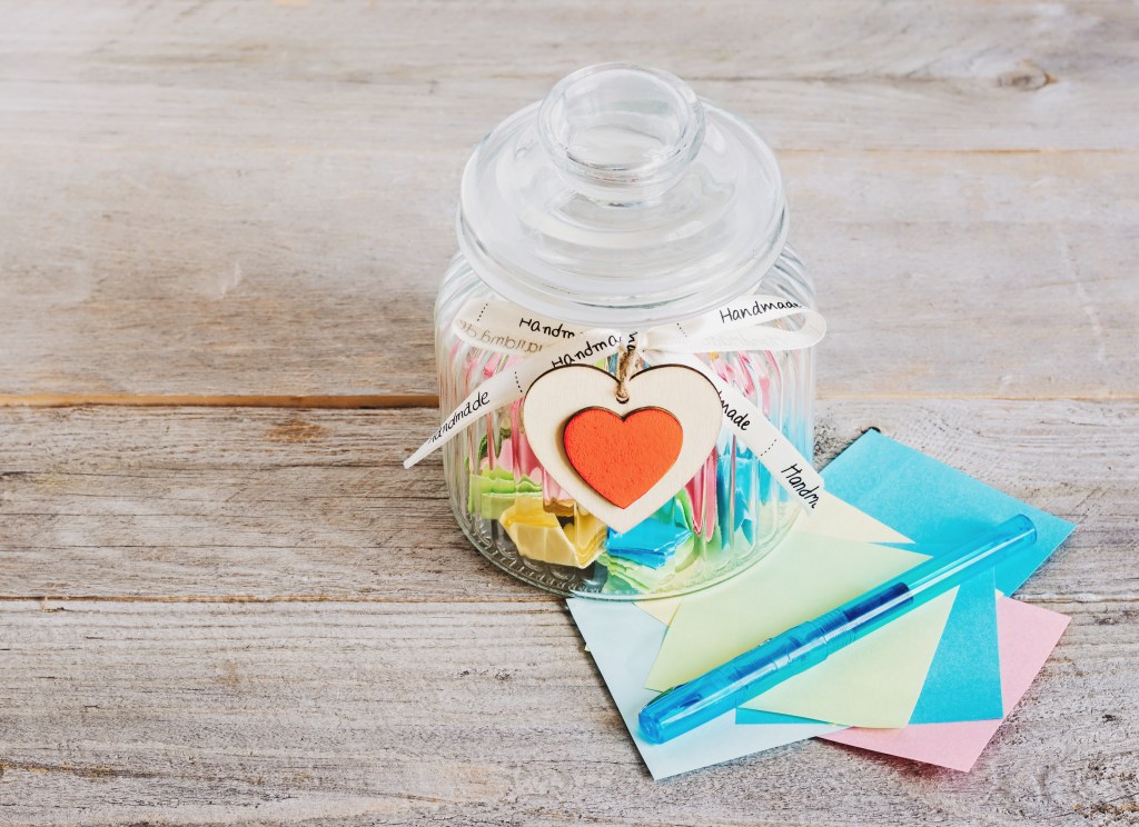Pot de verre contenant des petits papiers colorés